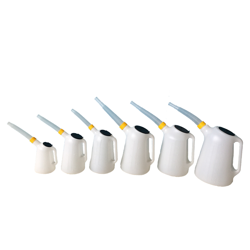 Various sizes of oil measuring jugs in a workshop environment